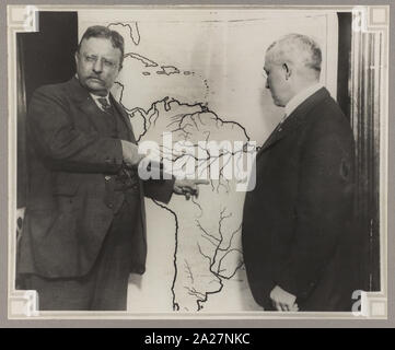 Il presidente Roosevelt puntando a una mappa di Sud America verso la zona esplorata durante la Roosevelt-Rondon spedizione scientifica in Brasile come un altro uomo guarda su Foto Stock