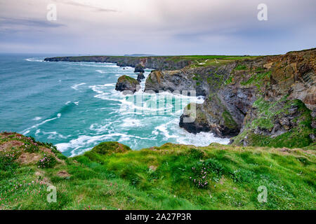 Tregurrian nel nord della Cornovaglia è un litorale mozzafiato con le onde che si infrangono contro gli scogli di un bel paesaggio Foto Stock