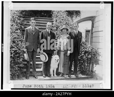 Presidente e signora Coolidge e a piena lunghezza ritratti, stando in piedi sui gradini, con i loro due figli e il loro cane Foto Stock