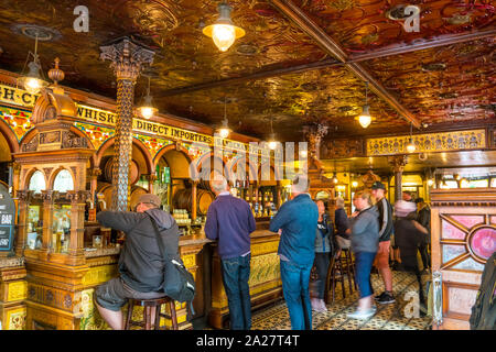 La gente in attesa di essere serviti all'interno di the landmark Crown Bar nel centro di Belfast, Irlanda del Nord, Regno Unito Foto Stock