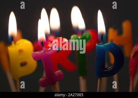 Bright happy birthday candele su una torta di compleanno Foto Stock