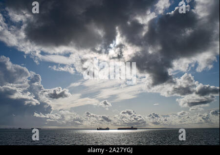 Southend UK 01 Ottobre 2019 - due grandi navi da carico passa da ogni altro nell'estuario del Tamigi off del Southend costa come essi vengono illuminate dal sole con nuvole temporalesche overhead di raccolta come le estremità di coda di uragano Lorenzo si dirige verso la Gran Bretagna nei prossimi giorni . Credito : Simon Dack / Alamy Live News Foto Stock