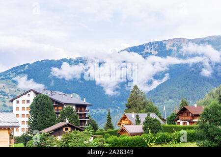 Villaggio nelle Alpi Svizzere sullo sfondo delle montagne di nebbia. Foto Stock