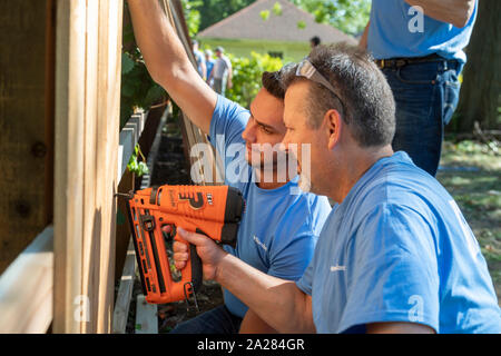 Detroit, Michigan - Volontari da Cooper standard di installare attrezzature e recinzioni in una nuova comunità del parco nel quartiere di Morningside. Foto Stock