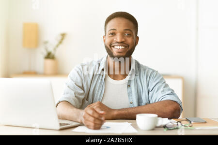 Felice African American freelancer seduti al posto di lavoro in ufficio a casa Foto Stock