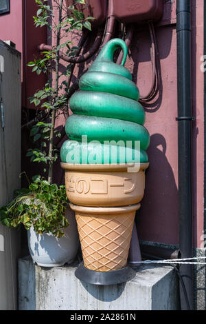 Grande in plastica sporca cono gelato verde con gelato e testo giapponese sul cono; Kyoto, Giappone Foto Stock