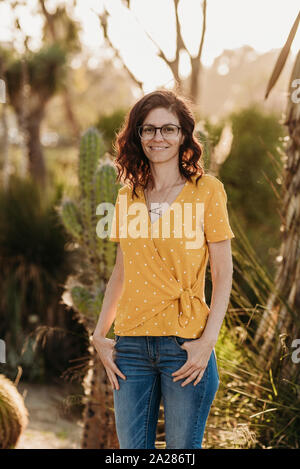 Headshot ritratto di metà femmina adulta madre con occhiali, esterno Foto Stock