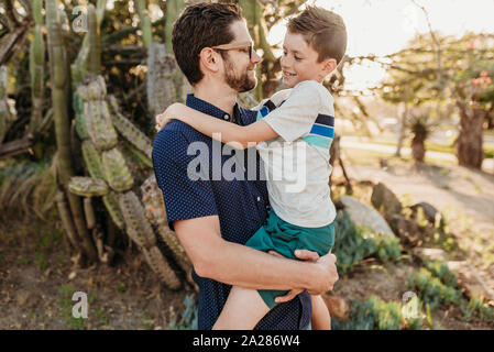 Ritratto di Padre mantenere vecchi figlio e sorridente ad ogni altro Foto Stock