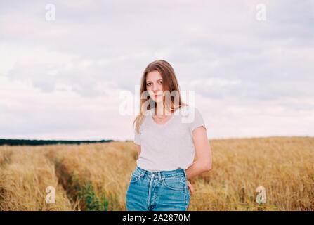 Donna in piedi in un campo di grano Foto Stock