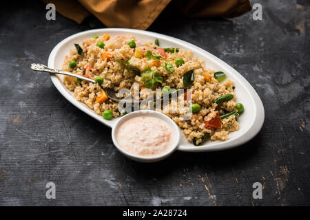 Rotture di frumento o Daliya Upma, servita in una ciotola messa a fuoco selettiva Foto Stock