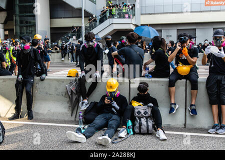 Hong Kong, Cina. 01 ott 2019. Manifestanti prendendo una pausa durante la dimostrazione.entrando nel XVIII Settimana di disordini civili, i manifestanti hanno marciato sulla mattina di Cina della giornata nazionale che celebra il settantesimo anniversario della Repubblica popolare di Cina di quest'anno. Manifestanti hanno intonato slogan e ha continuato a chiedere per le cinque richieste che devono essere soddisfatte. I dimostranti si sono scontrati con la polizia e sono stati colpiti con gas lacrimogeni e pallottole di gomma e acqua di cannoni e infine molti sono stati arrestati. Credito: SOPA Immagini limitata/Alamy Live News Foto Stock