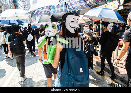 Hong Kong, Cina. 01 ott 2019. Protester con maschere e un Pepe la bambola di rana durante la dimostrazione.entrando nel XVIII Settimana di disordini civili, i manifestanti hanno marciato sulla mattina di Cina della giornata nazionale che celebra il settantesimo anniversario della Repubblica popolare di Cina di quest'anno. Manifestanti hanno intonato slogan e ha continuato a chiedere per le cinque richieste che devono essere soddisfatte. I dimostranti si sono scontrati con la polizia e sono stati colpiti con gas lacrimogeni e pallottole di gomma e acqua di cannoni e infine molti sono stati arrestati. Credito: SOPA Immagini limitata/Alamy Live News Foto Stock