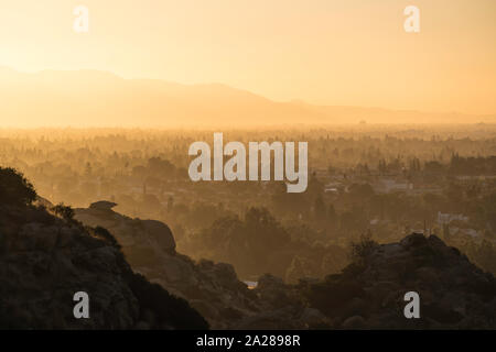 Fumoso sole mattutino al di sopra di San Fernando Valley Ovest i quartieri della città di Los Angeles, California. Le montagne di San Gabriel sono in backg Foto Stock