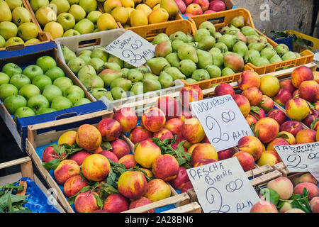 Le mele e le pesche in vendita in un mercato di napoli, Italia Foto Stock