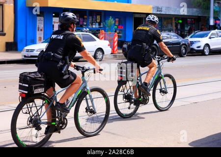 Due ufficiali della polizia di andare in bicicletta lungo la 4th Ave in Tucson AZ Foto Stock