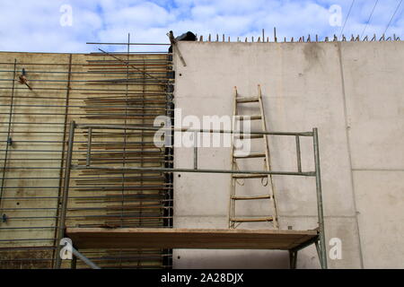 Scala sulla piattaforma superiore su una impalcatura Foto Stock