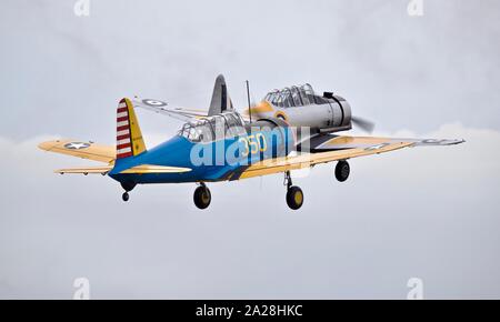 Vultee BT-13 Valiant (N313BT) e un North American NA-64 Yale decollare da eseguire al 2019 Battaglia di airshow di Gran Bretagna all'IWM Duxford Foto Stock