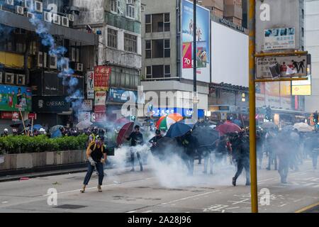 La polizia antisommossa fire gas lacrimogeni verso i manifestanti.entrando nel XVIII Settimana di disordini civili, i manifestanti hanno marciato sulla mattina di Cina della giornata nazionale che celebra il settantesimo anniversario della Repubblica popolare di Cina di quest'anno. Manifestanti hanno intonato slogan e ha continuato a chiedere per le cinque richieste che devono essere soddisfatte. I dimostranti si sono scontrati con la polizia e sono stati colpiti con gas lacrimogeni e pallottole di gomma e acqua di cannoni e infine molti sono stati arrestati. Foto Stock