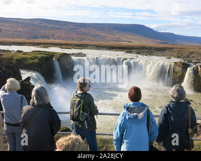 I turisti si riuniscono per ammirare cascate Godafoss o 'cascata degli dèi' un top ten destinazione nel nord dell'Islanda, noti per la loro tonante flusso d'acqua. Foto Stock