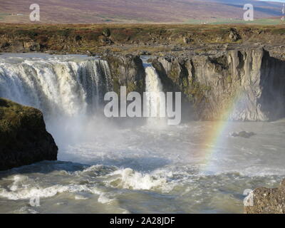 Un arcobaleno di moduli in spray sopra le cascate Godafoss, una delle più scenografiche cascate in Islanda. Foto Stock