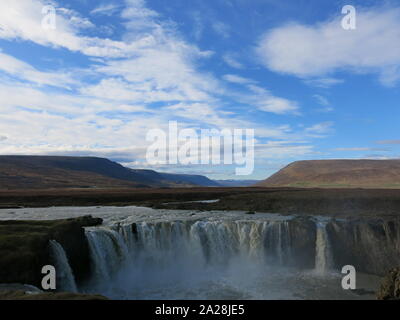 Il cielo blu sopra cascate Godafoss o 'cascata degli dèi", una top ten destinazione turistica nel nord dell'Islanda, noti per la loro tonante flusso d'acqua. Foto Stock