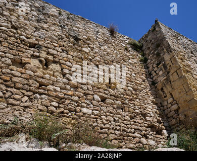 Parte della vecchia architettura, il vecchio muro di pietra contro un cielo blu Foto Stock