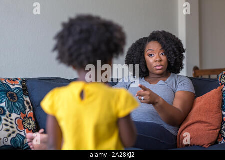 Madre afroamericana disciplinare parentando il suo bambino giovane. Foto Stock