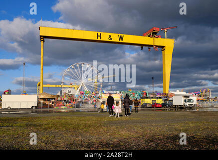 Funderland viaggiare parco dei divertimenti di impostare in Titanic Quarter a Belfast con corse sotto la H&W gru Foto Stock