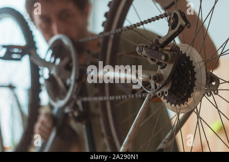 Meccanico di bicicletta la riparazione di vecchi mountain bike in officina, il fuoco selettivo Foto Stock