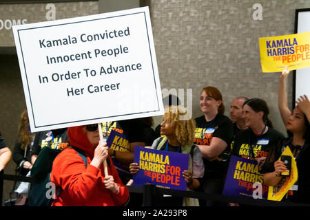 Un Protester contro STATI UNITI Il Sen. Kamala Harris passeggiate nei pressi di una folla di suoi sostenitori al DNC Incontri estivi a San Francisco il 23 agosto 2019. Foto Stock