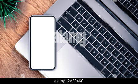 Smartphone e modello di laptop, isolata su una tavola di legno. Mockup. Foto Stock