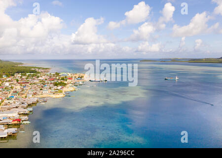 Porto di mare nella città di Dapa, Filippine. Villaggio di Pescatori e navi, vista dall'alto. Seascape in tempo soleggiato. Foto Stock