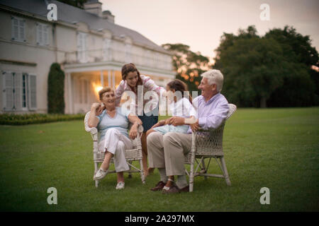 Ritratto di una famiglia seduta su un prato. Foto Stock