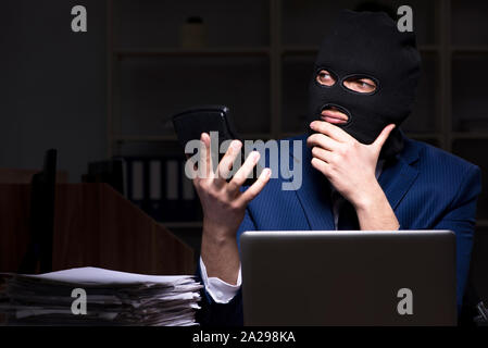 Il dipendente di sesso maschile di rubare informazioni in ufficio tempo di notte Foto Stock