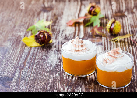 Dessert autunnale, mousse di zucca con panna montata in bicchieri Foto Stock