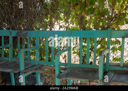 Un vintage banco blu da un vecchio cinema sta sotto un albero Foto Stock