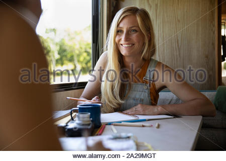 Giovane donna pianificazione viaggio con notebook in camper