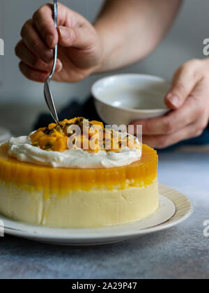 Passione Fuit Mango Cheesecake sulla piastra bianca Foto Stock