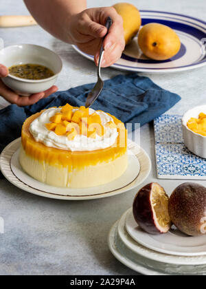 Passione Fuit Mango Cheesecake sulla piastra bianca Foto Stock