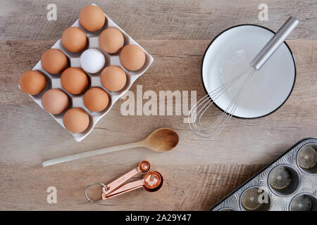 Bianco di ceramica vassoio contenente undici marrone e uno bianco uovo nel piatto composizione laici sul legno rustico sfondo. Mangiare sano concetto. Foto Stock