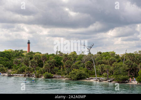 Paddle boarders viaggiare lungo il fiume indiano passato Giove faro di ingresso presso il South Beach ponte di Jupiter, Florida. Foto Stock