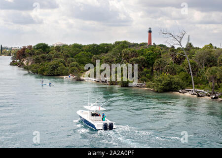 Barche di corsa lungo il fiume indiano passato Giove faro di ingresso presso il South Beach ponte di Jupiter, Florida. Foto Stock