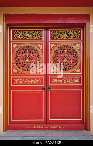 Un ornato porta rossa a Jui Tui tempio, Phuket Town, Phuket, Tailandia Foto Stock