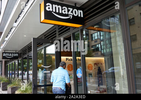 Portland, Oregon, Stati Uniti d'America - Sep 13, 2019: un uomo entra in un mozzo di Amazon Locker posizione, un self-service per luogo di consegna per il prelevamento e il ritorno dei pacchetti di Amazon. Foto Stock