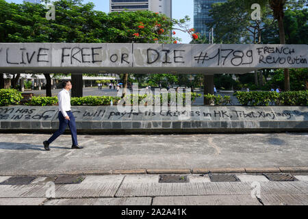 Il 2 ottobre 2019. Hong Kong riprende il business la mattina dopo violente proteste il 1 ottobre 2019. Graffiti di protesta si trova sull isola di Hong Kong dopo la Giornata nazionale di protesta. Foto Stock