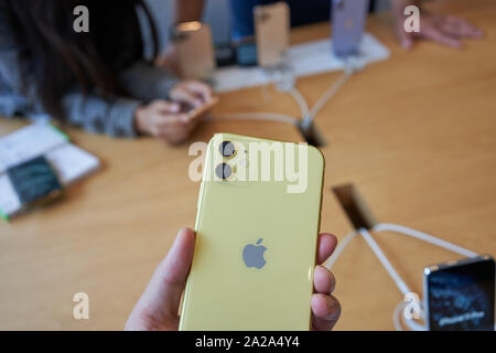 Portland, Oregon, Stati Uniti d'America - Sep 26, 2019: una shopper prende uno sguardo più da vicino al dual telecamere su un nuovo iPhone 11 in un Apple Store nel centro di Portland. Foto Stock