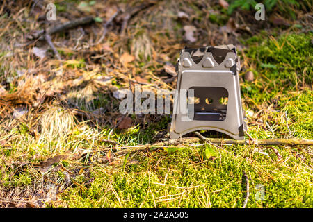 La piegatura la stufa a legna progettato per cucinare all'aperto con ramoscelli come combustibile su sfondo natura Foto Stock