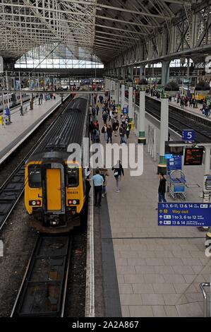 Ai passeggeri di salire e scendere una classe 156 Super Sprinter con il treno alla Stazione Ferroviaria Manchester Piccadilly Station Foto Stock