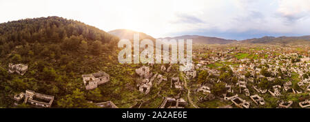 Vista aerea guardando sopra una città abbandonate su un lato della montagna di sunrise Foto Stock