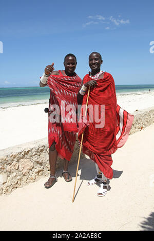 Due uomini Maasai permanente sulla spiaggia, Zanzibar, isola di Unguja, Tanzania. Foto Stock